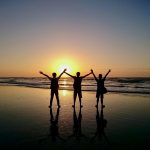 friends on a beach at sunset